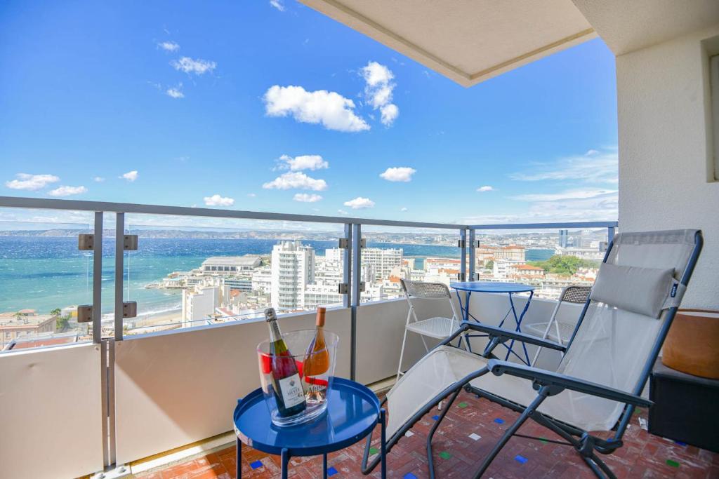 - un balcon avec des chaises et une table avec des bouteilles de vin dans l'établissement L'Horizon - 3 ch climatisé avec vue mer incroyable, à Marseille