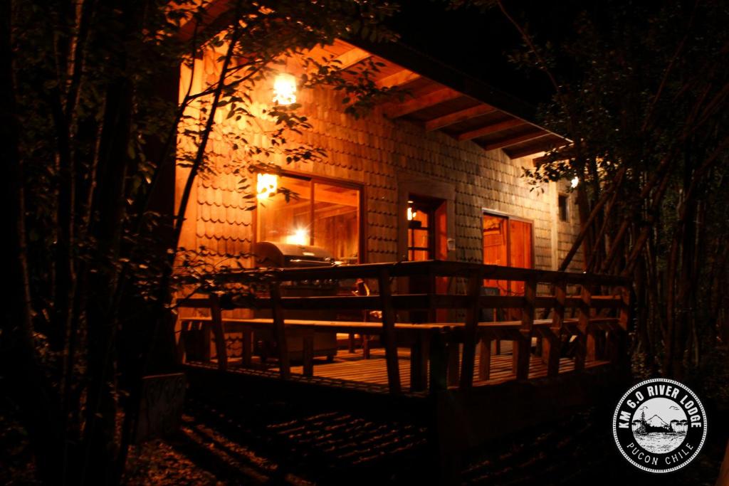 uma casa com um alpendre à noite com luzes em River Lodge em Pucón