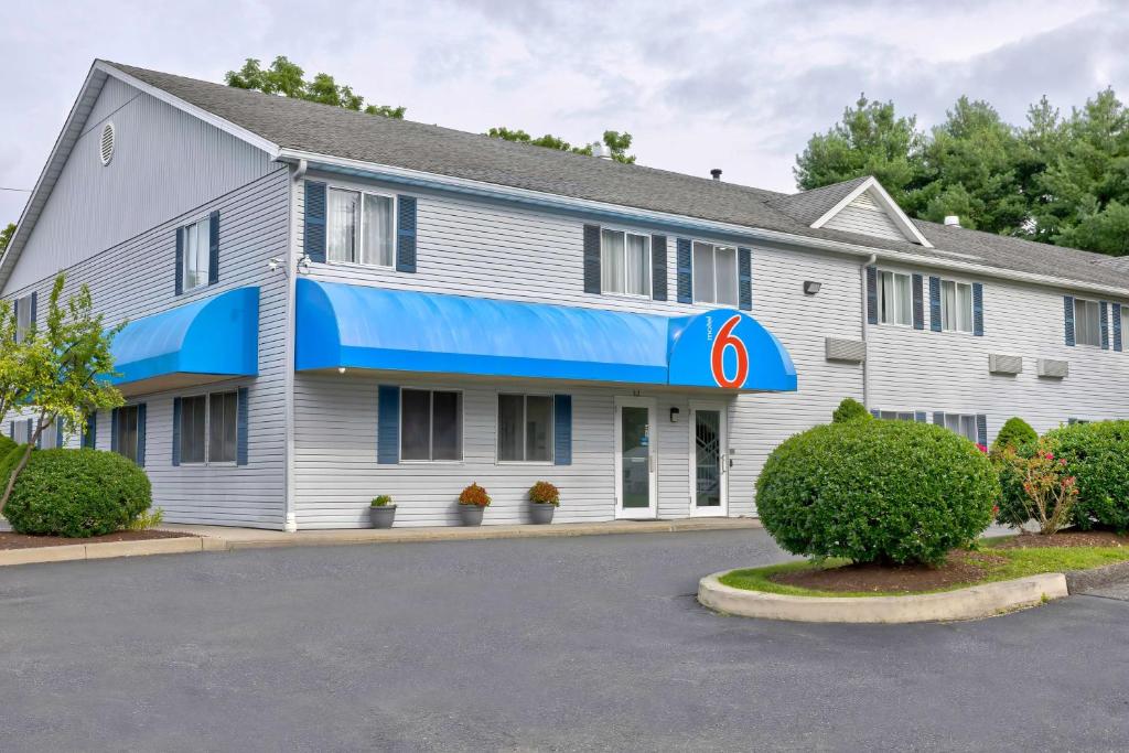 a large white building with a blue awning at Motel 6 Bethel, CT - Danbury in Bethel