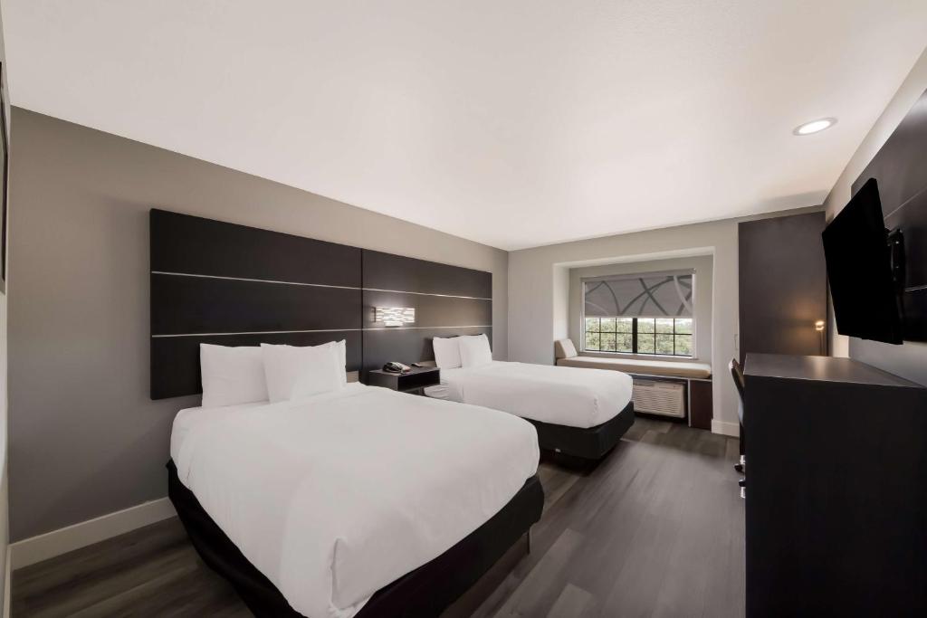 Habitación de hotel con 2 camas y TV en Best Western SeaWorld San Antonio, en San Antonio