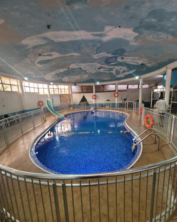 a large swimming pool in a building with a painted ceiling at PALM GROVE APARTMENT in Lagos