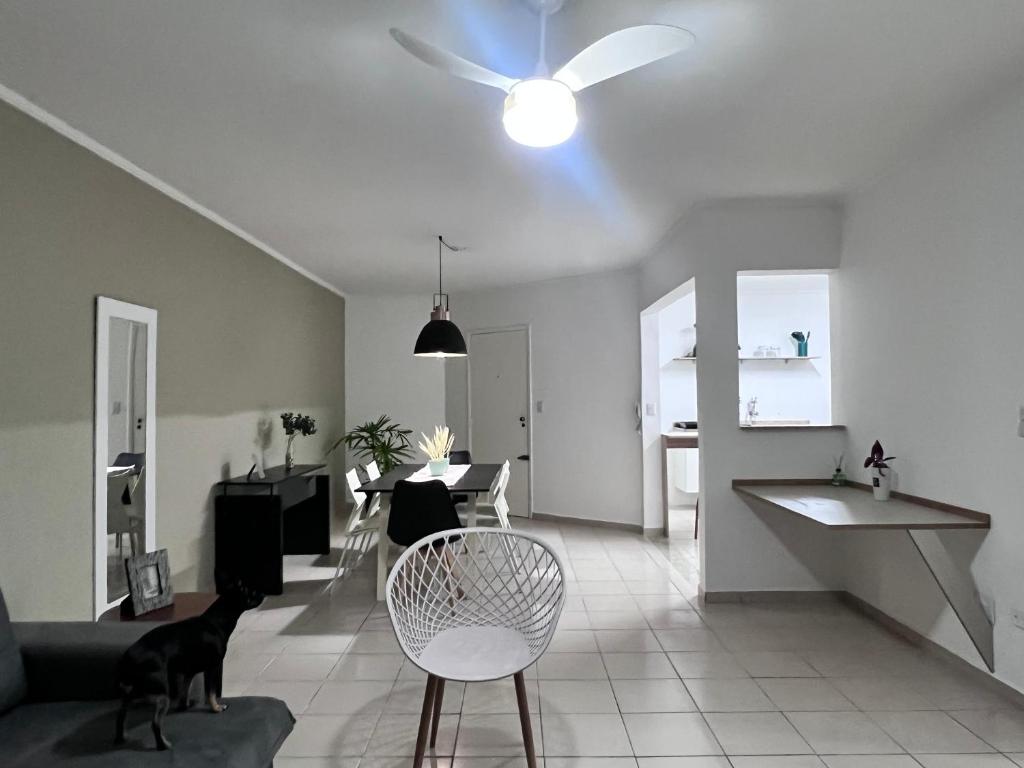 a living room with a ceiling fan and a couch at AeK apartamento conforto praia in Peruíbe