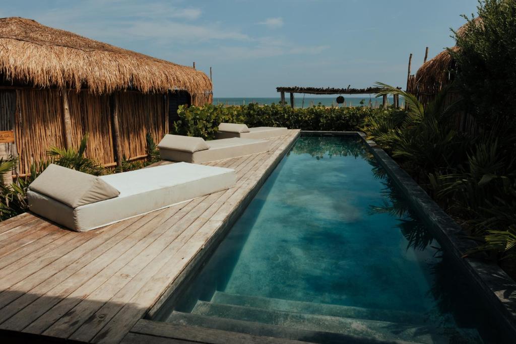 a swimming pool with chairs and a wooden deck at Casa Ku Hotel - Adults Only in San Bruno