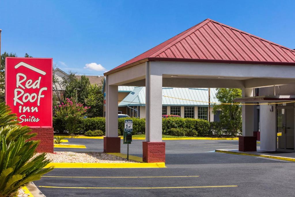 a red roof inn with a sign in a parking lot at Red Roof Inn & Suites Statesboro - University in Statesboro