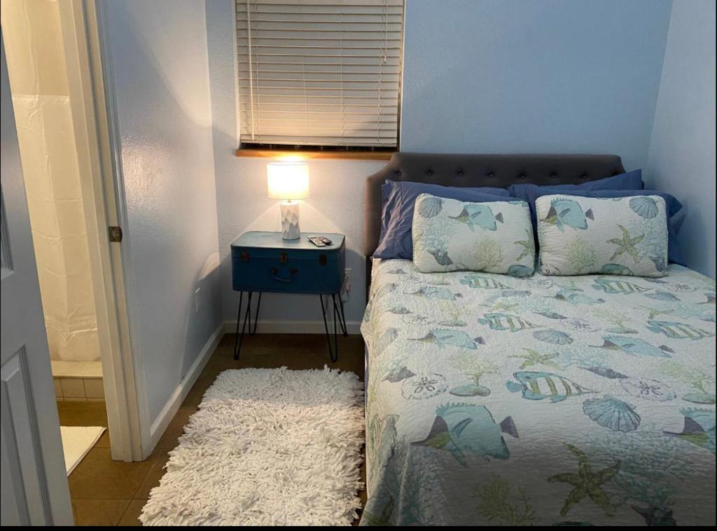 een slaapkamer met een bed en een nachtkastje met een lamp bij Seaside bungalow in Daytona Beach