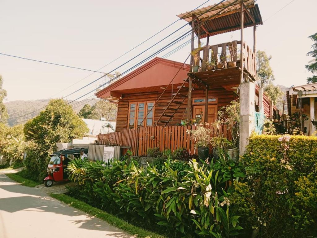 une maison en bois avec un balcon dans une rue dans l'établissement 20/20 wood cabana, à Nuwara Eliya