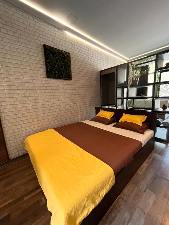 a bedroom with a large bed with yellow sheets at Varna Cathedral Apartments in Varna City