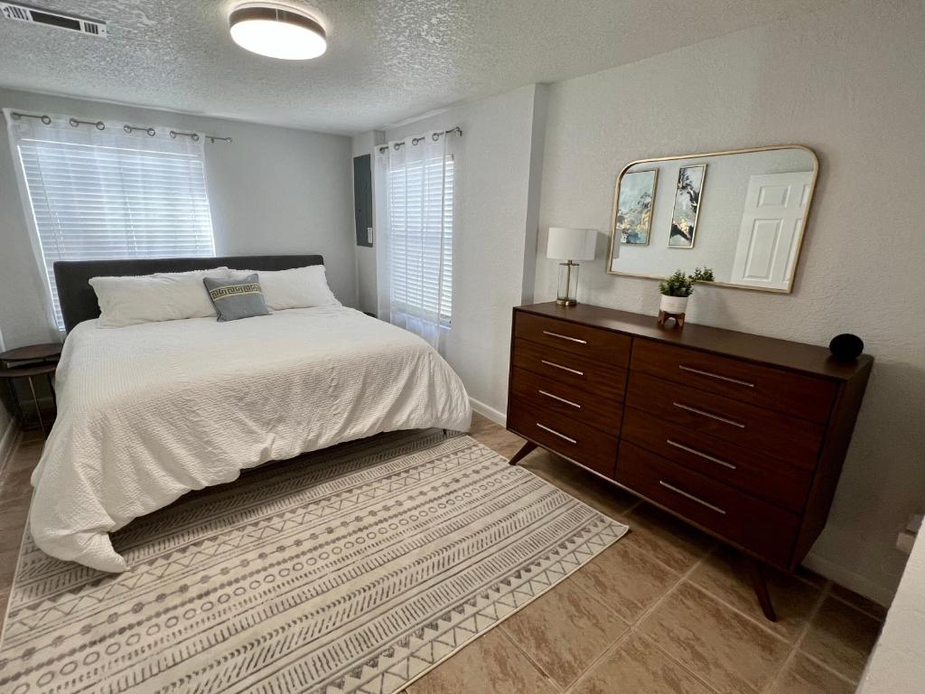 a bedroom with a bed and a dresser and a mirror at Beautiful Bungalow in Orlando