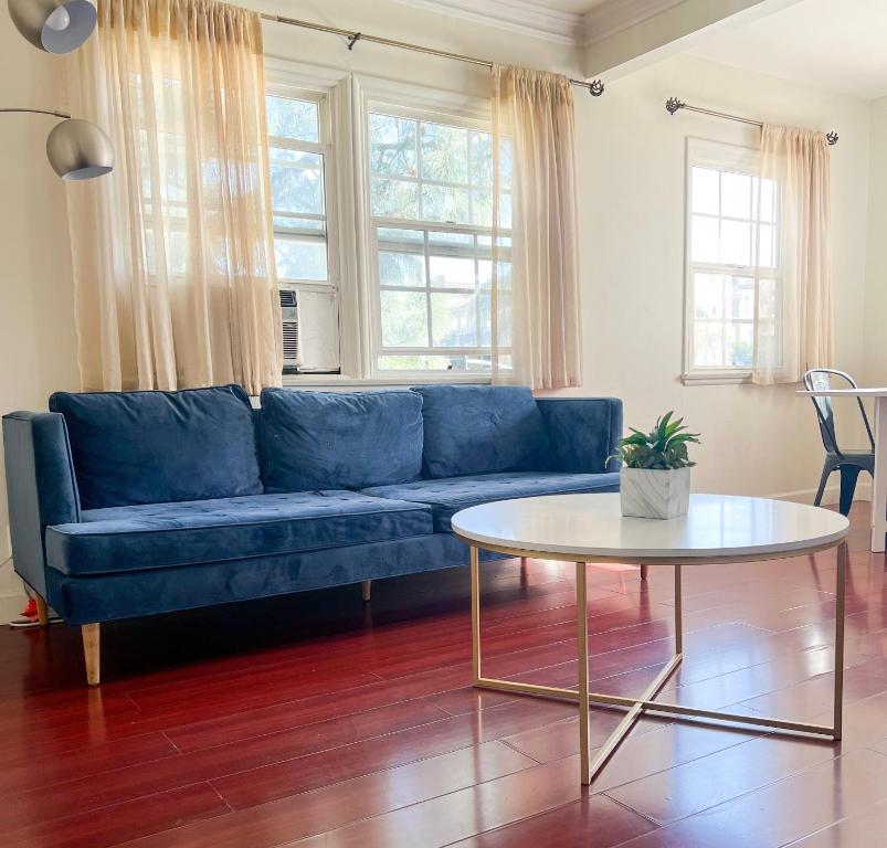 a blue couch in a living room with a table at Charming Century City Condo in Los Angeles