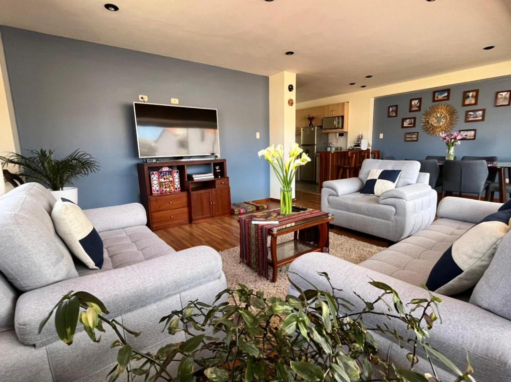 ein Wohnzimmer mit Sofas und einem Flachbild-TV in der Unterkunft hermoso departamento en zona residencial de cusco in Cusco