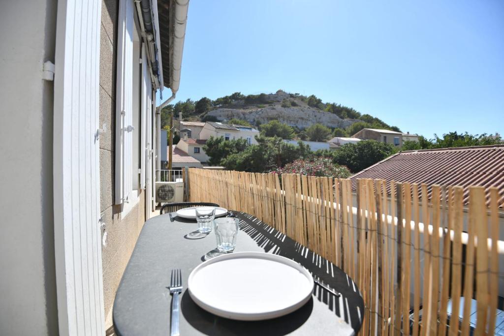 einen Balkon mit einem Tisch, Stühlen und einem Zaun in der Unterkunft Appart 1 ch clim - 50m des plages et des Calanques in Marseille