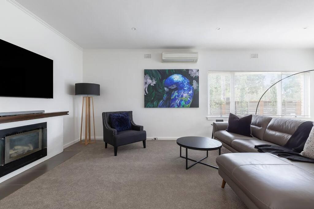 a living room with a couch and a fireplace at Botanical Oasis in Frankston