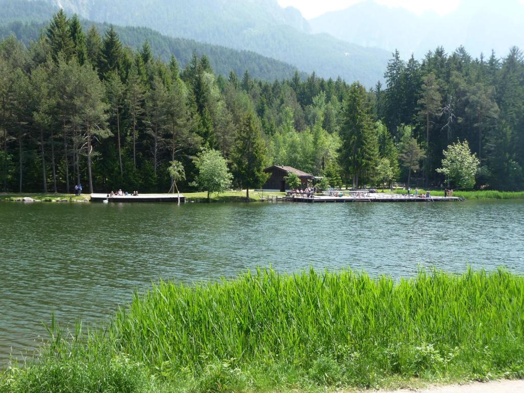 einen See mit einer Gruppe von Menschen auf einem Dock in der Unterkunft Villa Grünewald in Seis am Schlern