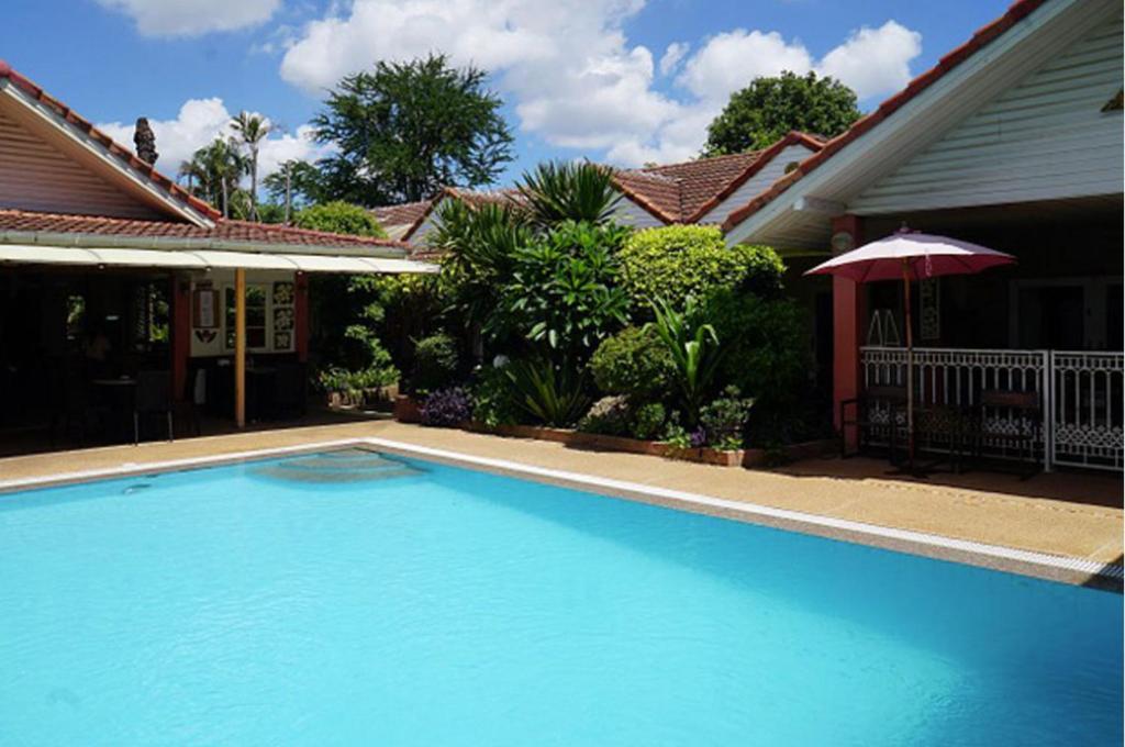 a swimming pool in front of a house at Udon Thai House Resort & Hotel in Udon Thani