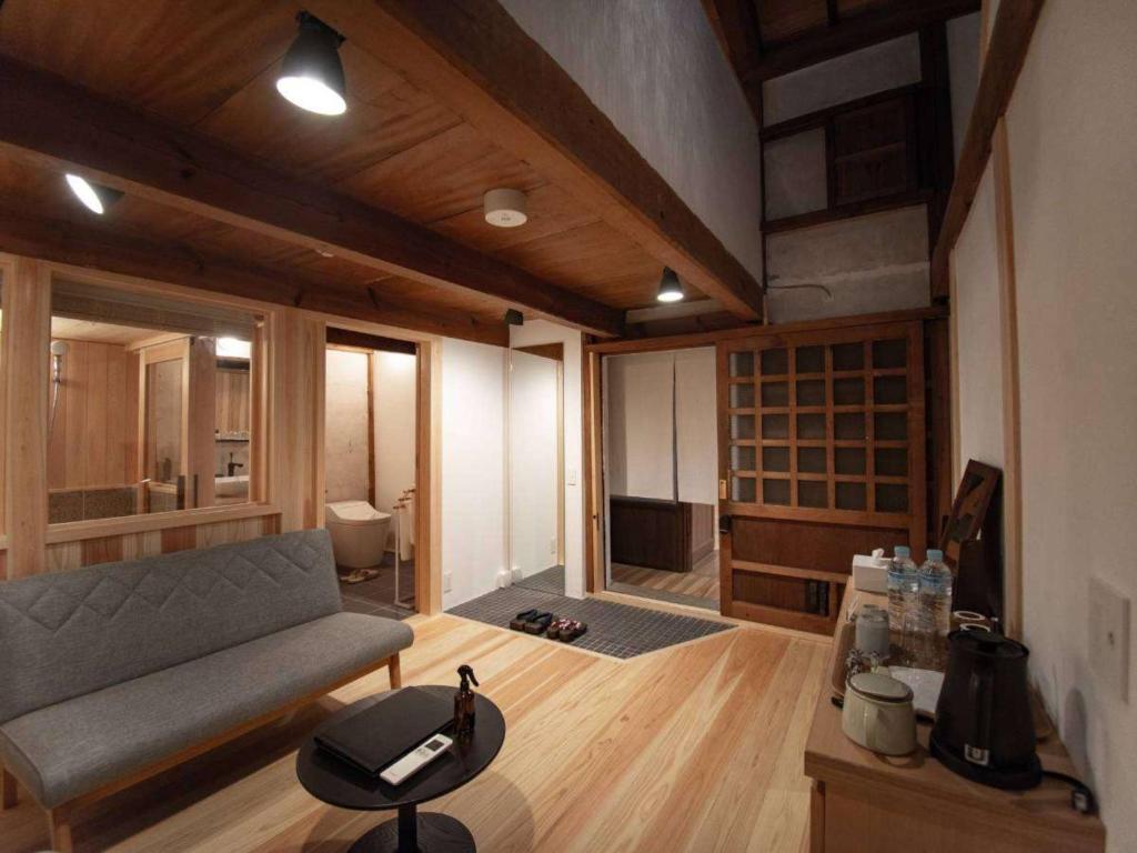 a living room with a couch and a tv in a room at NIPPONIA HOTEL 伊賀上野 城下町 in Iga