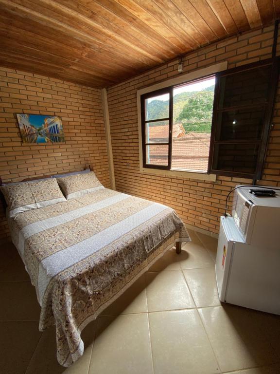 a bedroom with a bed in a brick wall at Flat Trindade in Trindade