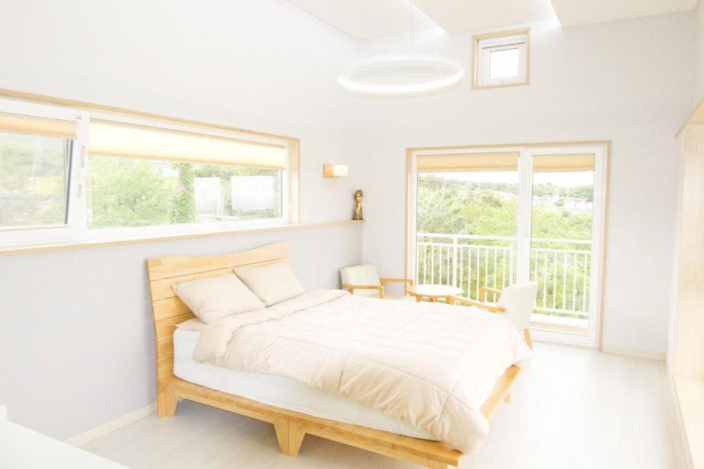 Habitación blanca con cama y ventana en Jeju Bomewasan en Jeju