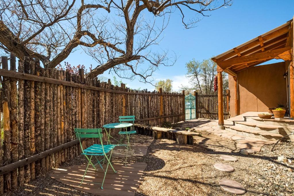 two chairs and a table in front of a fence at Nob Hill Home with Private Yard! in Albuquerque