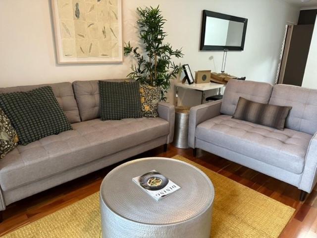 a living room with two couches and a table at Adelaide Dress Circle Apartments - Archer Street in Adelaide