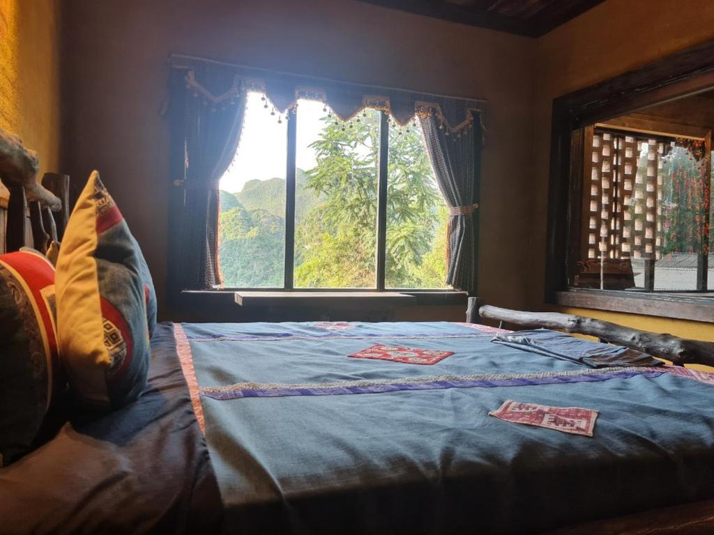 Bett in einem Zimmer mit Fenster in der Unterkunft Quan Din Ngai Villa in Dồng Văn