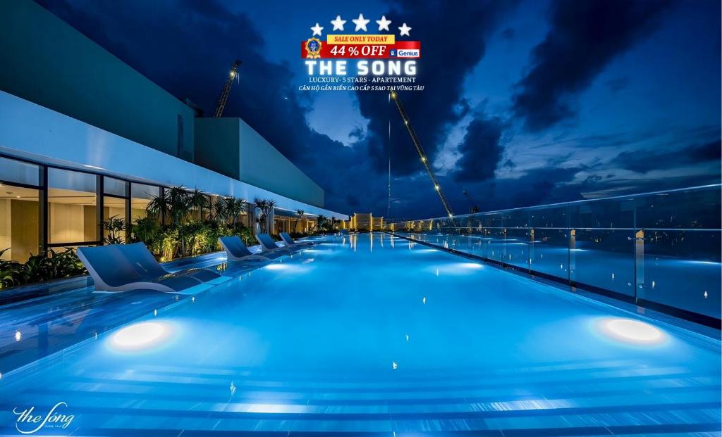 een zwembad 's nachts met een bord dat het lied leest bij THE SONG VŨNG TÀU - Five-Star Luxury Apartment - Căn Hộ Du Lịch 5 Sao Cạnh Biển in Vung Tau