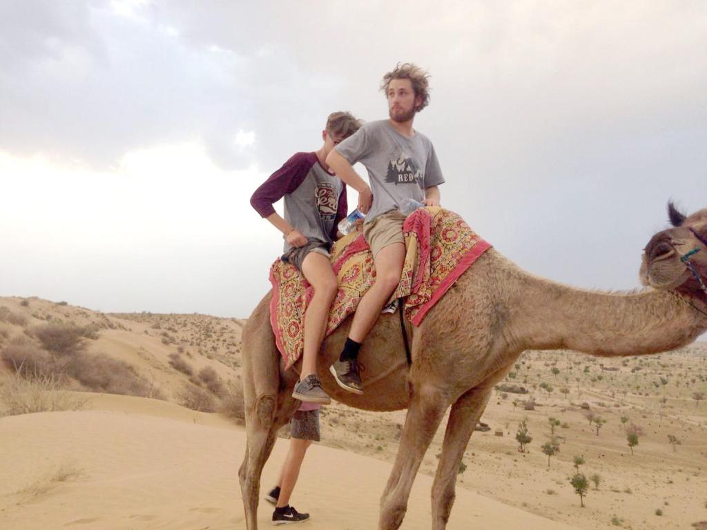 two men riding on a camel in the desert at Madhu Singh Dhani Home Stay -Ridmalsar in Champasar