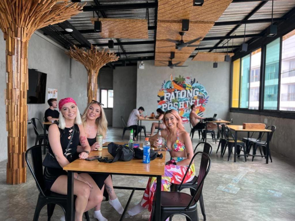 three women sitting at a table in a restaurant at Patong Poshtel in Patong Beach