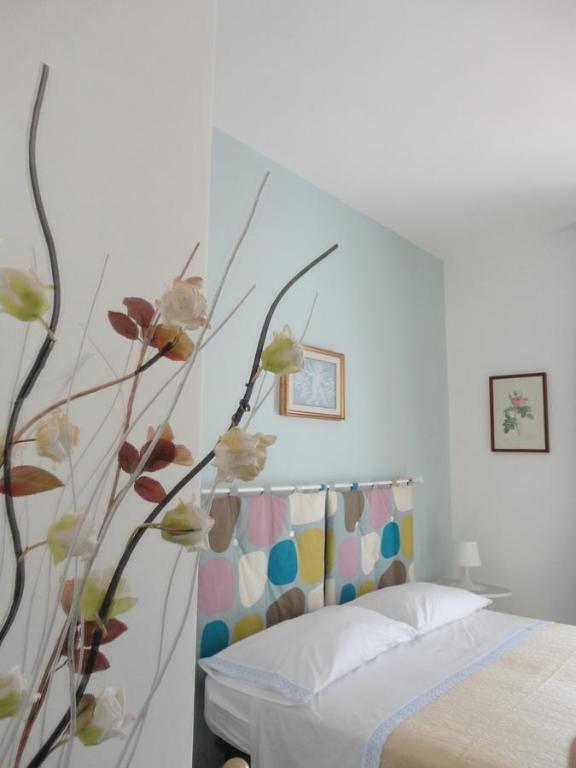 パリヌーロにあるB&B Cristinaの花の壁のベッドルーム1室(ベッド1台付)