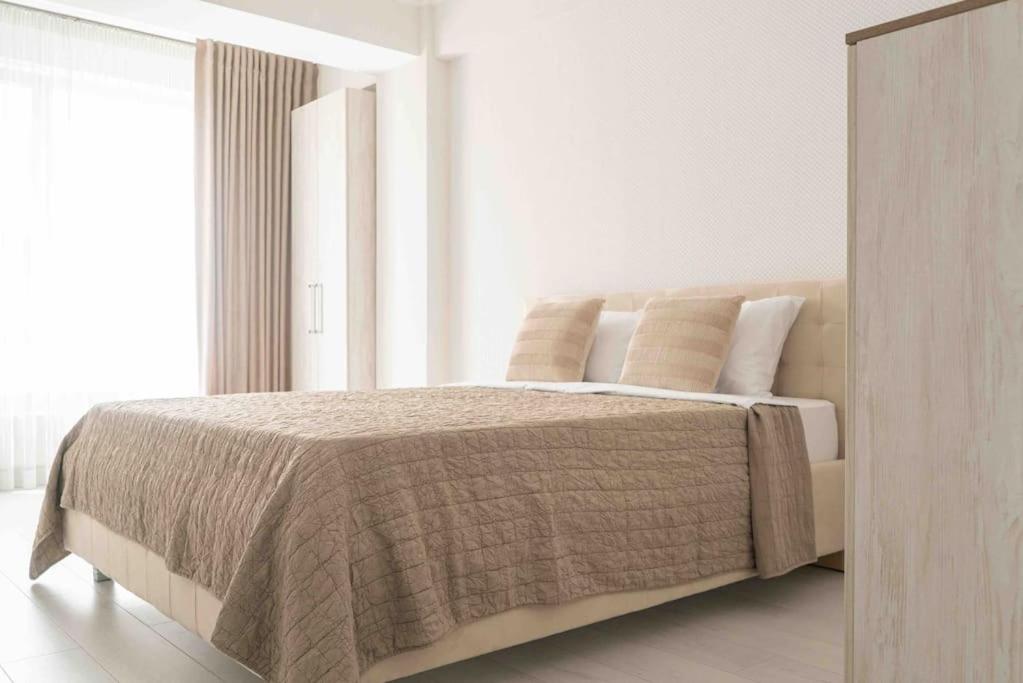 a bedroom with a large bed and a window at RentWill apartments Double in Chişinău