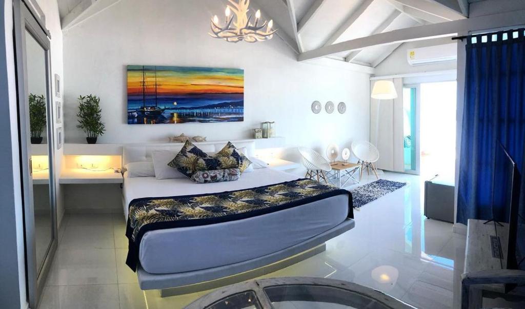 - une chambre avec un lit et une peinture murale dans l'établissement Hotel Tropical in isla de punta arena, à Carthagène des Indes