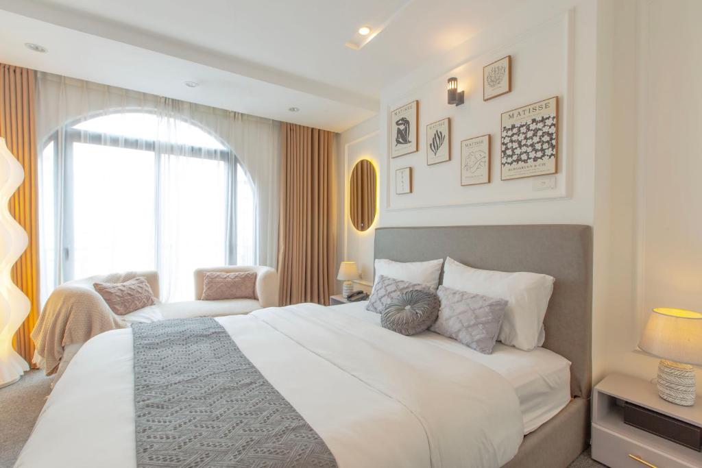 una camera da letto con un grande letto bianco e una finestra di Keypad Hotel - 87 Nguyễn Khang a Hanoi