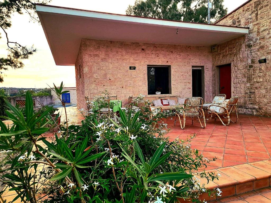 a patio with chairs and tables on a brick building at Villa Rossi in Polignano a Mare