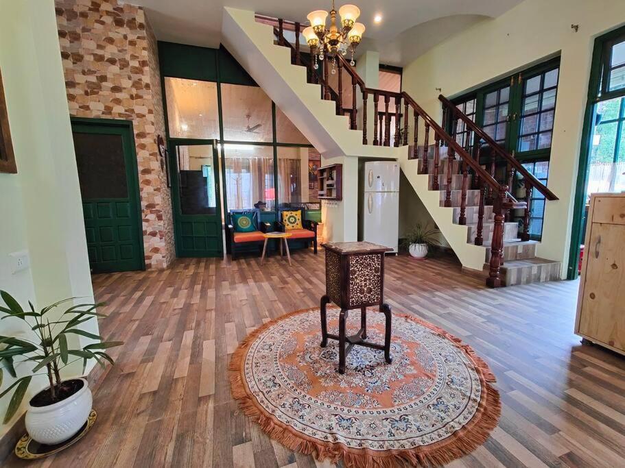 a room with a staircase and a chair on a rug at Aviator's Bungalow - Dharamshala in Dharamshala
