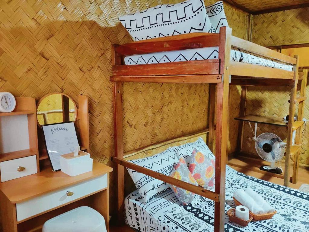 1 dormitorio con litera, escritorio y cama en El Nido Backpackers Guesthouse en El Nido