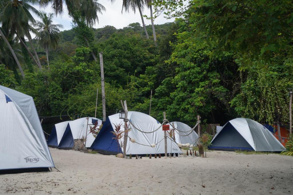 a group of tents on a beach with trees at Redang Campstay in Redang Island
