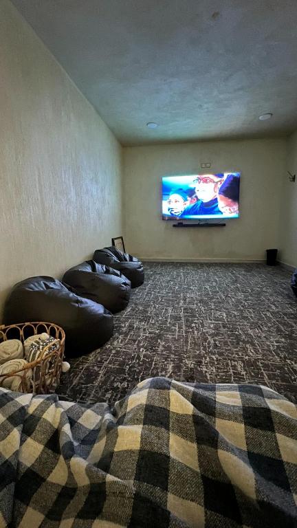 a living room with bean bags and a flat screen tv at The Gate in Sur