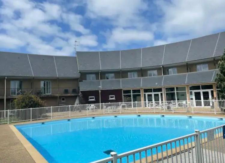 una gran piscina frente a un edificio en Studio Piscine Honfleur Deauville, en Équemauville