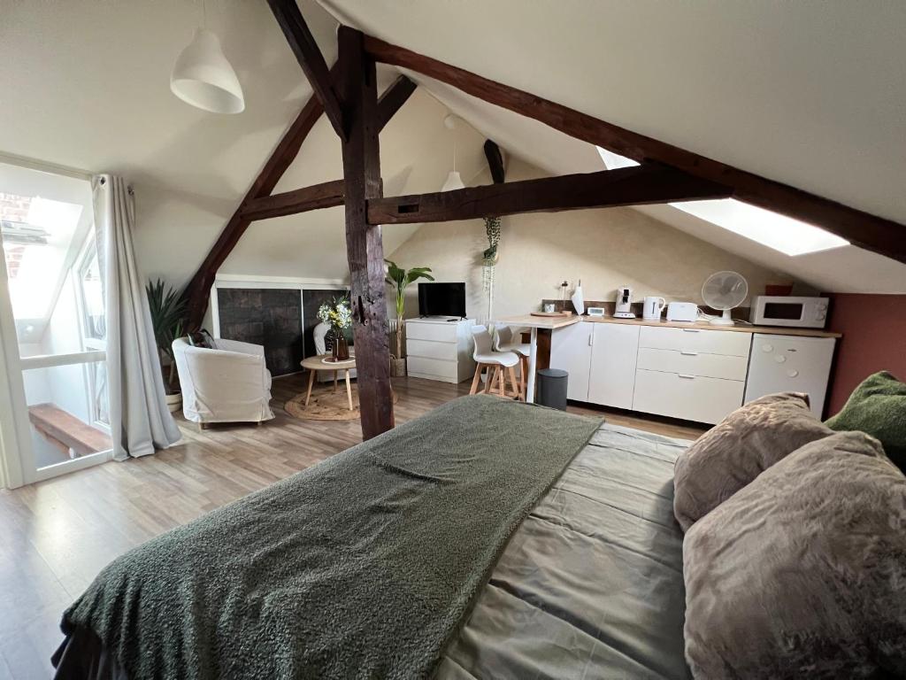 1 dormitorio con 1 cama grande y cocina en La Madeleine, en Châteaugiron
