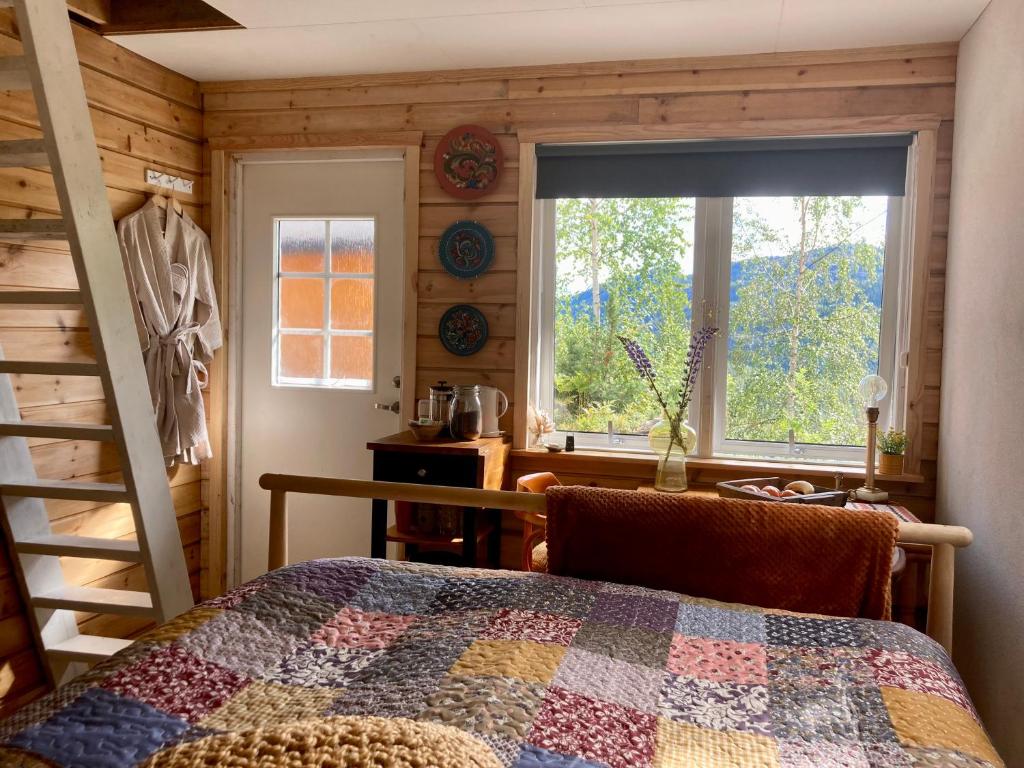 1 dormitorio con edredón en la cama y ventana en Fritt!, 