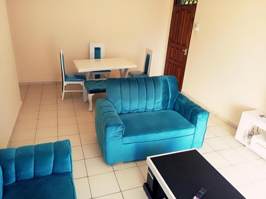 sala de estar con sofá azul y mesa en Bliss homestay apartment with swimming pool en Mtwapa