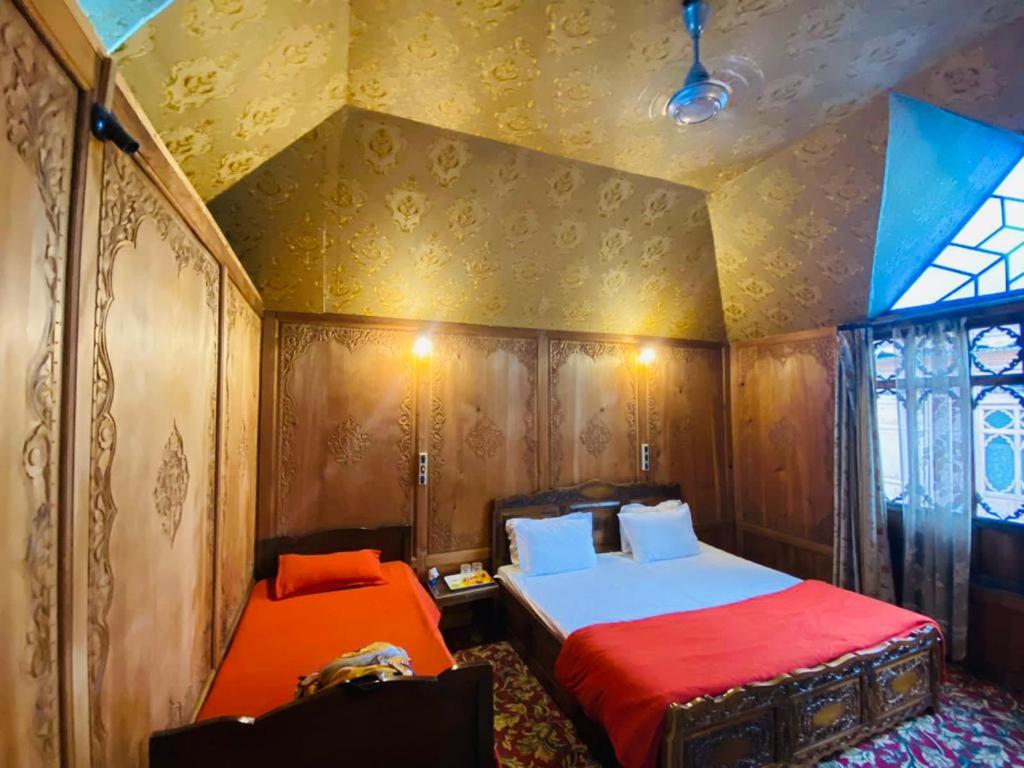 1 Schlafzimmer mit 2 Betten und einem Fenster in der Unterkunft Houseboat Kashmir Treat in Srinagar