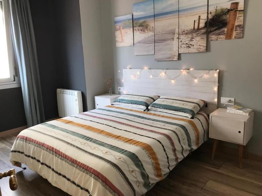 ein Schlafzimmer mit einem großen Bett mit Beleuchtung in der Unterkunft Piso céntrico cerca de la playa in A Coruña