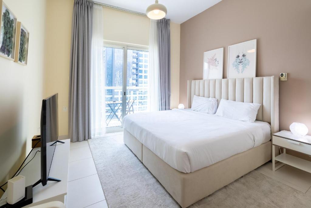 a bedroom with a bed and a tv and a window at Splendid Studio in Marina View Towers in Dubai