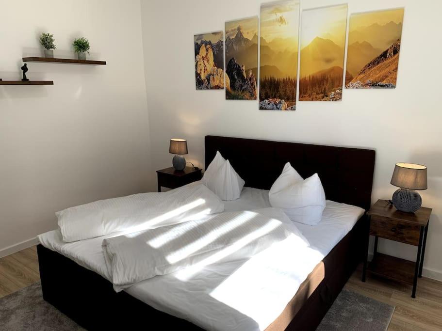 sypialnia z łóżkiem z białą pościelą i poduszkami w obiekcie Entspannen am Großen Goitzschesee inkl. Netflix w mieście Holzweißig