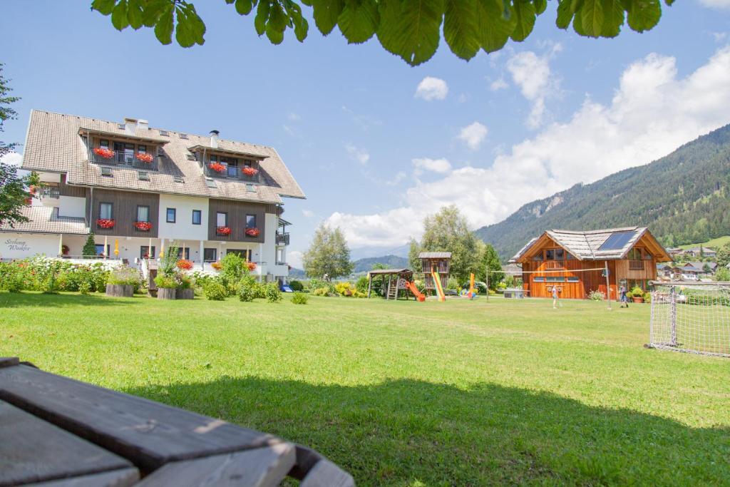 a park with a building and a playground at Seehaus Winkler in Weissensee