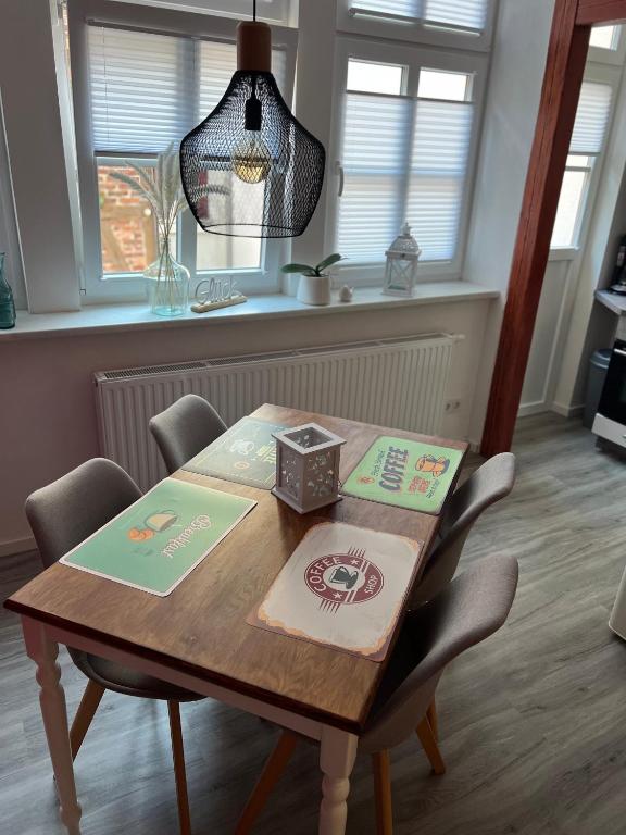 a dining room table with chairs and a light fixture at Altstadt Fewo Wernigerode in Wernigerode