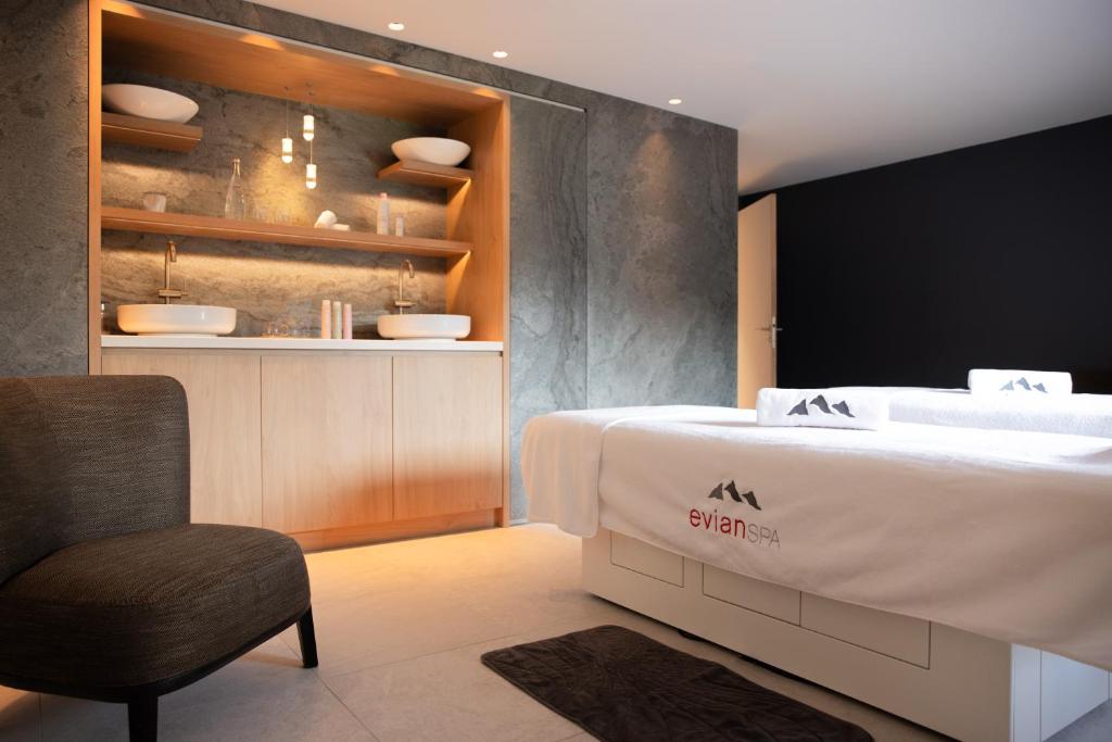 a bedroom with a white bed and a chair at Hôtel Royal in Évian-les-Bains