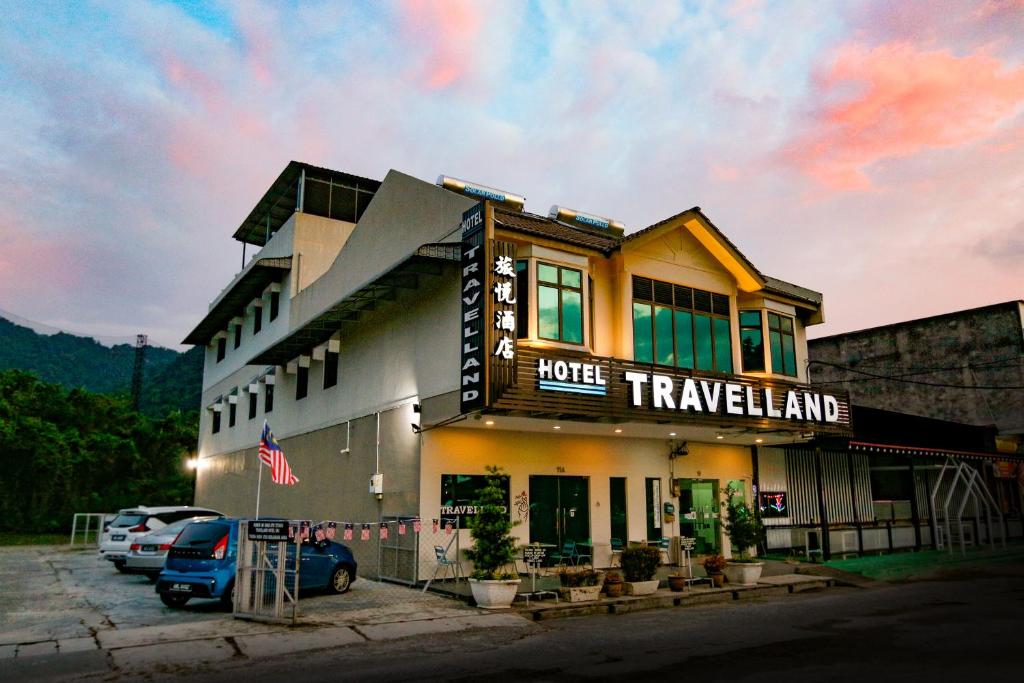 a hotel with cars parked in a parking lot at Travelland Hotel in Ipoh
