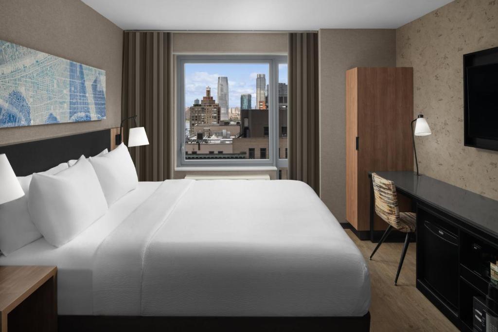 a hotel room with a large white bed and a window at Courtyard by Marriott New York World Trade Center Area in New York