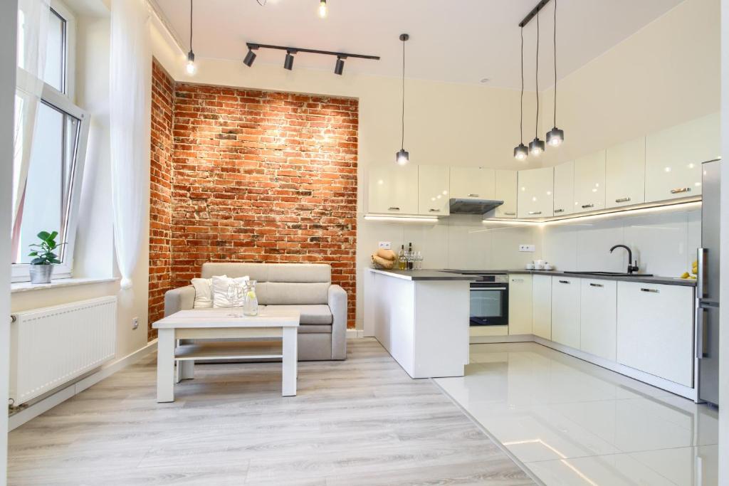uma cozinha e sala de estar com uma parede de tijolos em APARTAMANT DE LUX em Kluczbork
